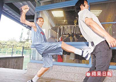 愛打籃球、自稱小時踢過足球的蘇安生(左)拿臺媒記者示范踢扁動作,架勢十足。